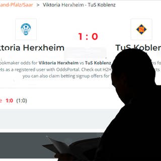 Eine Mann (als Schatten im Vordergrund) schaut sich die Quoten für interationales Sportveranstaltungen auf einer Webseite an.