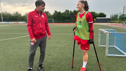 Amputierten - Fußballerin Nicola Roos steht ihrem Mainzer Trainer auf dem Fußballplatz
