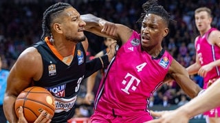 Der Ulmer Karim Jallow im schwarzen Trikot im Zweikampf gegen Phlandrous Fleming der Baskets Bonn.