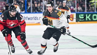 Eishockey-Nationalspieler Samuel Soramies (rechts im weiß-schwarzes Dress der DEB-Auswahl) im Lauf-Duell mit dem Kanadier Milan Lucic.