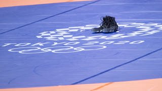 Die schwarzen Schuhe von Ringer Frank Stäbler stehen einsam und allein auf der Olympia-Matte von Tokio
