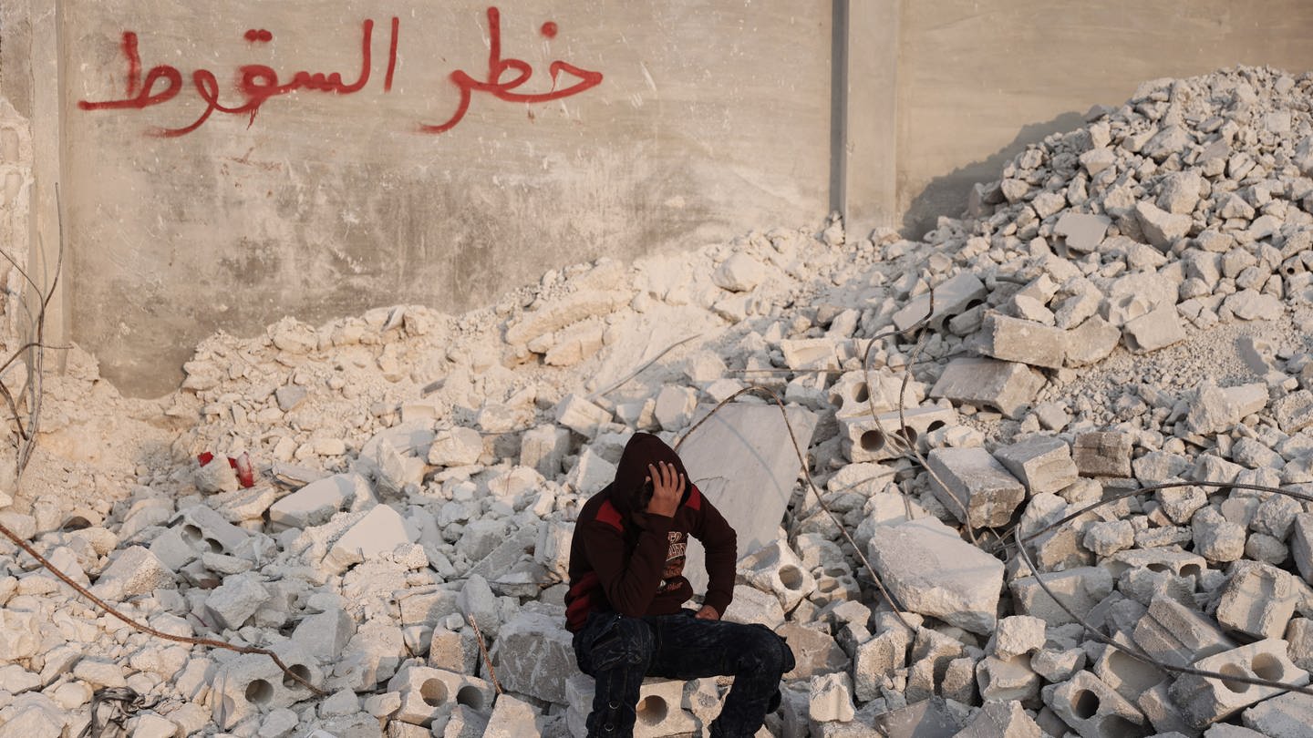 Der 15-jährige Muhammad Al-Mula sitzt in der Nähe seines zerstörten Hauses, das durch das Erdbeben an der türkisch-syrischen Grenze zerstört wurde. Al-Mula wurde gerettet, nachdem er fast zehn Stunden lang unter den Trümmern des Gebäudes eingeschlossen war, in dem er mit seinen fünf Familienmitgliedern gelebt hatte.