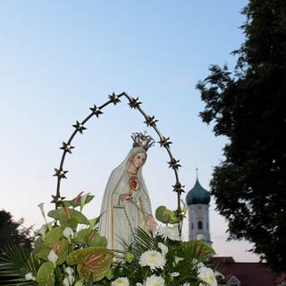 Eine blumengeschmückte Marienstatue wird auf eine Waldlichtung bei der Wallfahrtskirche Maria Vesperbild zu einem Gottesdienst getragen. Die Katholiken vor allem im Süden Bayerns feiern an Mariä Himmelfahrt einen ihrer traditionsreichsten Feiertage