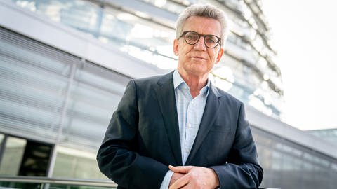 Thomas de Maiziere, ehemaliger Innen- und Verteidigungsminister, steht auf der Fraktionsebene des Bundestages vor der Reichstagskuppel
