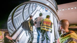 Polizeibeamte begleiten im Sommer 2019 einen Afghanen auf dem Flughafen Leipzig-Halle in ein Charterflugzeug 