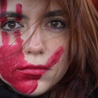 Eine Frau nimmt an einer Demonstration anlässlich des Internationaler Tags gegen Gewalt an Frauen teil.