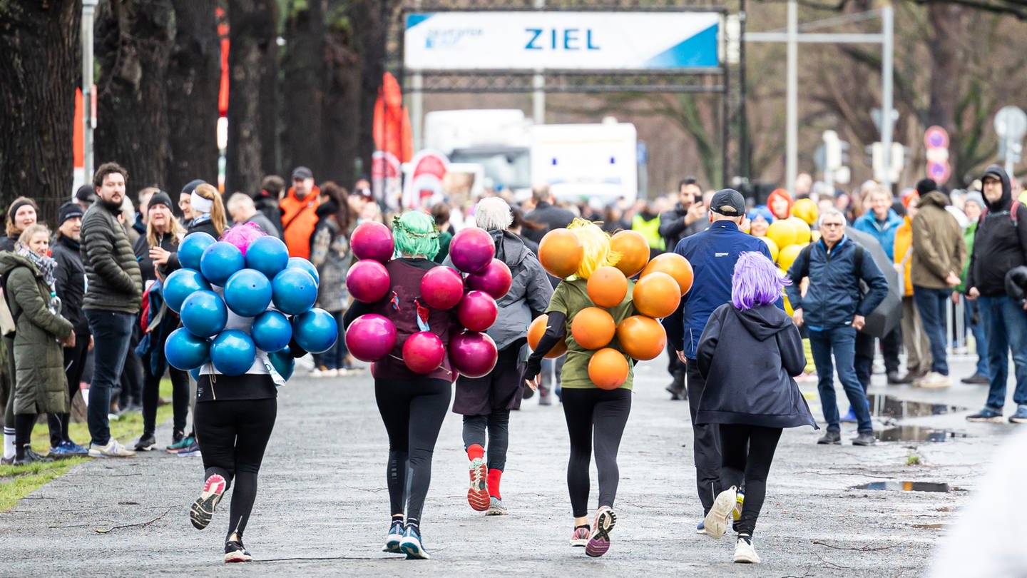 Kostümierte Teilnehmer laufen beim Silvesterlauf mit. Die rund 5,8 Kilometer lange Strecke führt die Läufer um den Maschsee.