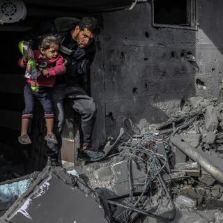 Palästinenser inspizieren beschädigte Wohngebäude, in denen Berichten zufolge zwei israelische Geiseln festgehalten wurden. 