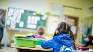 Schülerinnen und Schüler einer Grundschule sitzen in ihrem Klassenraum. 