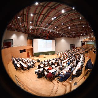 Studenten sitzen in der Universität während einer Vorlesung im Hörsaal. 