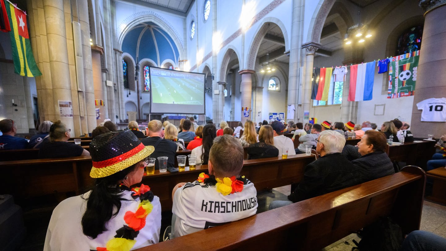 Besucher verfolgen das Spiel bei einem Public Viewing in der Kirche der Katholischen Kirchengemeinde St. Joseph Schalke.