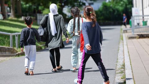 Eine Familie Flüchtlinge und Migranten gehen in der Zentralen Aufnahmeeinrichtung für Asylbewerber in Bayern Über das Gelände