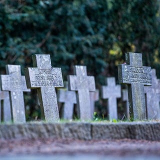 Grabkreuze am Kriegsgräber Denkmal auf einem Alten Friedhof.