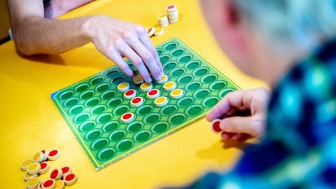 Ein Spieler setzt während einer Spielrunde des Spiels «Reversi» zweifarbige Spielsteine auf dem Spielfeld. 