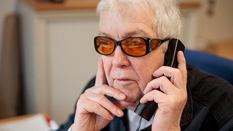 Gerhard Weingartner, ehrenamtlicher Mitarbeiter beim Seniorentelefon Dreiklang, hört am Telefon einem Anruf zu.