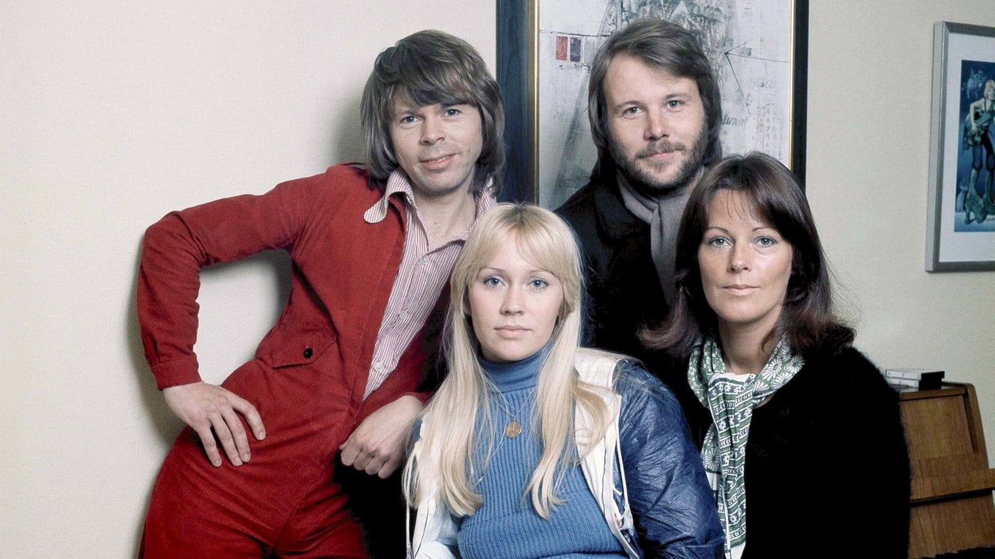 Die Bandmitglieder von ABBA schauen lächelnd in die Kamera.