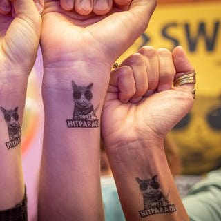 Vier Menschen halten ihre Handgelenke mit einem SWR1 Hitparaden-Tattoo in die Kamera