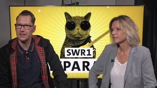 Die SWR1 Moderatoren Stefanie Anhalt und Jochen Stöckle sitzen auf Stühlen und lächeln in die Kamera.