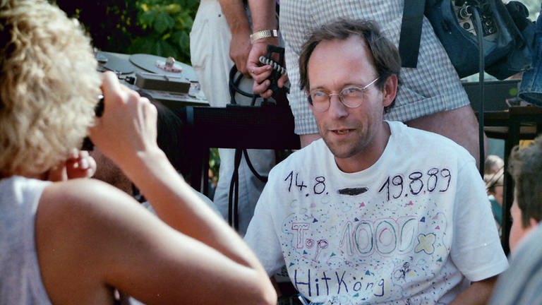 Stefan Siller mit einem bemalten weißen T-Shirt bei der Hitparade TOP 1000 X-Abschlussparty 1989