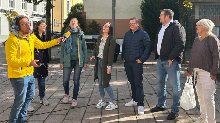 HITmach-Duell Nußloch: Ingo Lege singt mit einem kleinen spontanen Chor aus vier Frauen und zwei Männern.