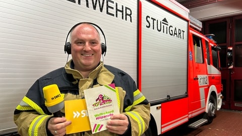 Hitparaden-Platzansager Andreas von der Freiwilligen Feuerwehr Stuttgart-Mühlhausen hält eine Broschüre der hitparade aus dem Jahr 1990.