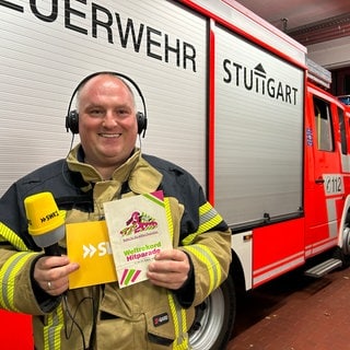 Hitparaden-Platzansager Andreas von der Freiwilligen Feuerwehr Stuttgart-Mühlhausen hält eine Broschüre der hitparade aus dem Jahr 1990.