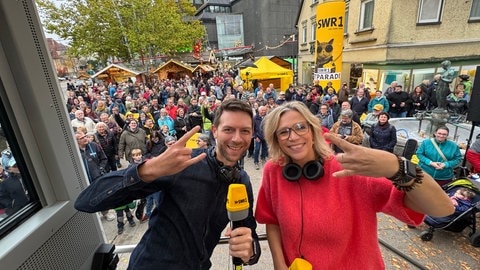 Corvin Tondera-Klein und Stefanie Anhalt stehen vor dem Publikum in Heidenheim während der SWR1 Hitparade.