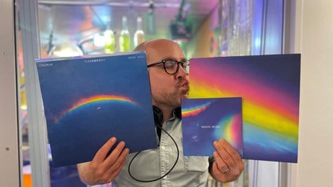 Max Oehl hält das Coldplay-Album "Mondmusik" in seinen Händen und küsst es. 