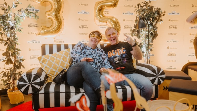 SWR1 Fans auf dem gestreiften Sofa vor goldener 35 im Hintergrund.