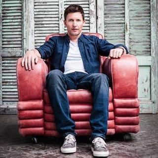 James Blunt sitzt in einem roten Sessel, 2013