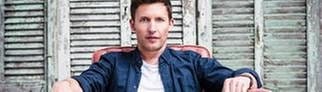 James Blunt sitzt in einem roten Sessel, 2013