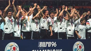 Deutsche Fußball-Nationalmannschaft jubelt am 30.6.1996 im Londoner Wembley-Stadion hinter dem Logo der EURO 96 gemeinsam über den Titelgewinn.