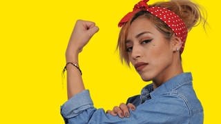 Beautiful woman dressed as the iconic Rosie the Riveter 