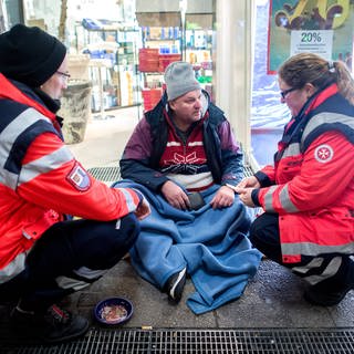 Ehrenamtlichen Helfer mit einem Obdachlosen