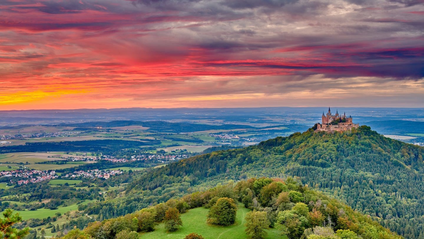Die Burg Hohenzollern in Baden-Württemberg auf einem bewaldeten Hügel lohnt sich für einen Ausflug.