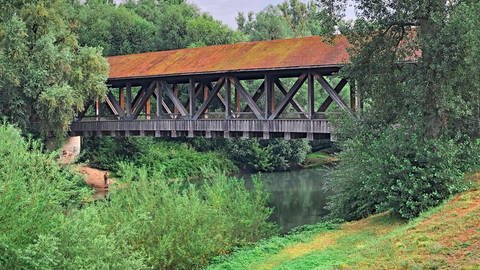 Eine Holzbrücke führt über den Kraichbach. Der Radweg führt überwiegend bergab. Deshalb ist der Kraichradweg ein sehr guter Tipp für einen Ausflug mit der ganzen Familie.