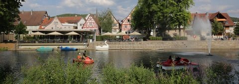 Tretboote im Fluss Nagold mit Blick auf die Stadt Nagold. Wir haben schöne Radwege und Radtouren in Baden-Württemberg gesammelt.