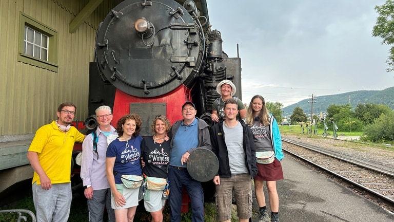 Der Perfekte Tag mit der Sauschwänzlebahn: von links nach rechts - SWR1 Moderator Ingo Lege mit Toby, Judith, Gewinnerin Daniela Nonnenmacher, Udo, Joël, Jenny und Sina, vor der großen Dampflok der Sauschwänzlebahn. 