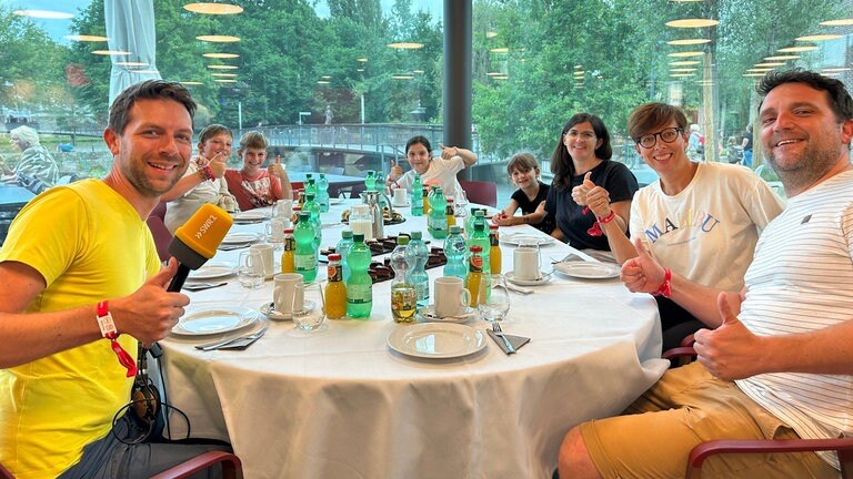 Der perfekte Tag mit SWR1 in der Experimenta Heilbronn: Die Gewinnergruppe sitzt am Tisch und streckt die Daumen in die Höhe - ein perfekter Tag!