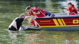 DLRG-Retter zeigen bei einer Übung, wie sie mit dem Boot einen erschöpften Schwimmer aus dem Wasser helfen.  Nur 43 Prozent trauen sich zu, jemanden vor dem Ertrinken zu retten, sagt die DLRG. Wir klären die wichtigsten Fragen rund um das Thema "Unfälle und Sicherheit beim Baden" und geben euch Tipps, wie ihr euch im Notfall richtig verhaltet.