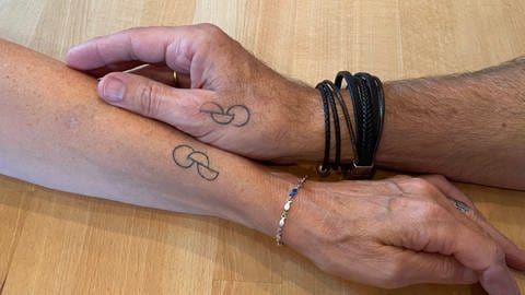 Das gemeinsame Tattoo von Kris und Frank: zwei ineinander verschlungene Halbkreise und ein Kreis. Es drückt sowohl die gemeinsame Verbundenheit aus als auch die offizielle Bereitschaft zur Organspende. SWR1 Neuanfang: Kris rettet mit einer Organspende ihrem Mann Frank das Leben.