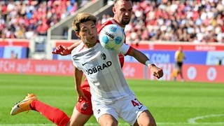 Der 1. FC Heidenheim spielt gegen den SC Freiburg in der Fußball-Bundesliga. Ritsu Doan vom SC Freiburg ist im Zweikampf mit Heidenheims Benedikt Gimber.