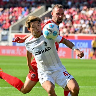 Der 1. FC Heidenheim spielt gegen den SC Freiburg in der Fußball-Bundesliga. Ritsu Doan vom SC Freiburg ist im Zweikampf mit Heidenheims Benedikt Gimber.