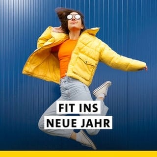 Eine junge Frau mit gelber Winterjacke und Jeans springt vor einem blauen Hintergrund in die Luft. Startet fit ins neue Jahr mit SWR1! Mit gesunden Rezepten, und den besten Fitness-Tipps.