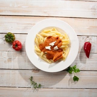 Auf einem Teller angerichtet: Pasta mit einer Tomaten-Paprika-Sauce und Mozzarella