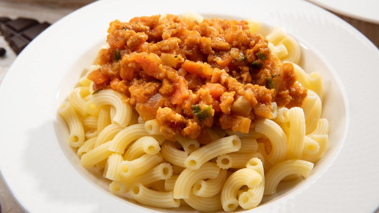 Auf einem Teller mit Pasta eine vegane Saucen-Variante: Kürbis-Bolognese.