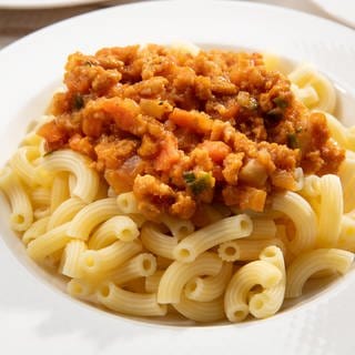 Auf einem Teller mit Pasta eine vegane Saucen-Variante: Kürbis-Bolognese.