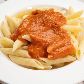 Auf einem Teller angerichtet: Pasta mit einer Tomaten-Paprika-Sauce und Mozzarella