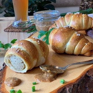 Eine Weißwurst im Brezelteigmantel.