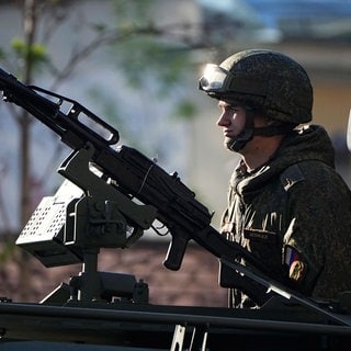 Ein russischer Soldat steht in einem Fahrzeug, das in Richtung Roter Platz fährt, um an einer Militärparade zum Tag des Sieges in Moskau, Russland, teilzunehmen, die am Dienstag, den 9. Mai 2023, dem 78. Jahrestag des Endes des Zweiten Weltkriegs stattfindet.